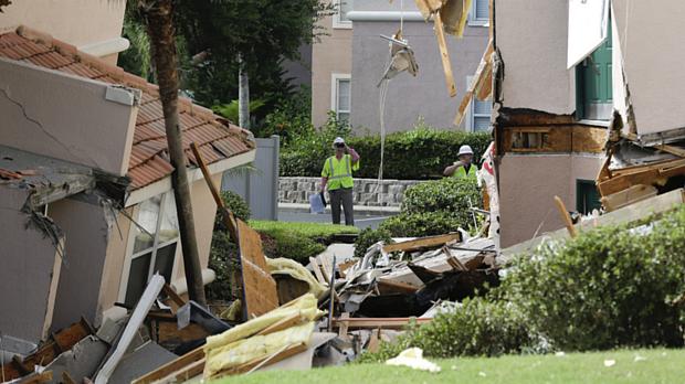 Inspetores observam danos provocados por buraco que destruiu construções em Clermont, na Flórida