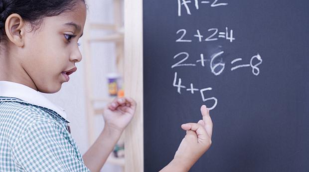 Criança aprende matemática na sala de aula