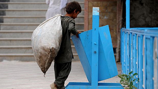 Criança vasculha lixo no Afeganistão