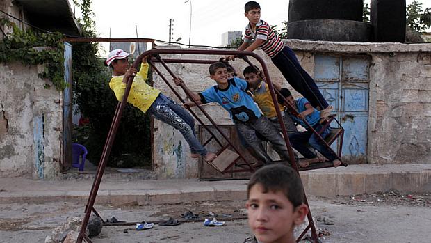 Crianças sírias brincam na cidade destruída de Alepo