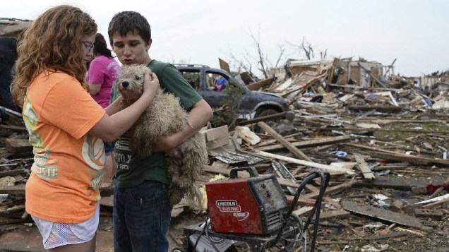 Crianças com seu cão diante de área devastada por tornado no distrito de Moore, em Oklahoma
