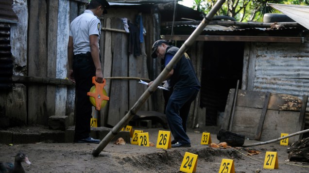 Equipe de perícia trabalha no local onde sete pessoas foram assassinadas em Las Escobas, Guatemala