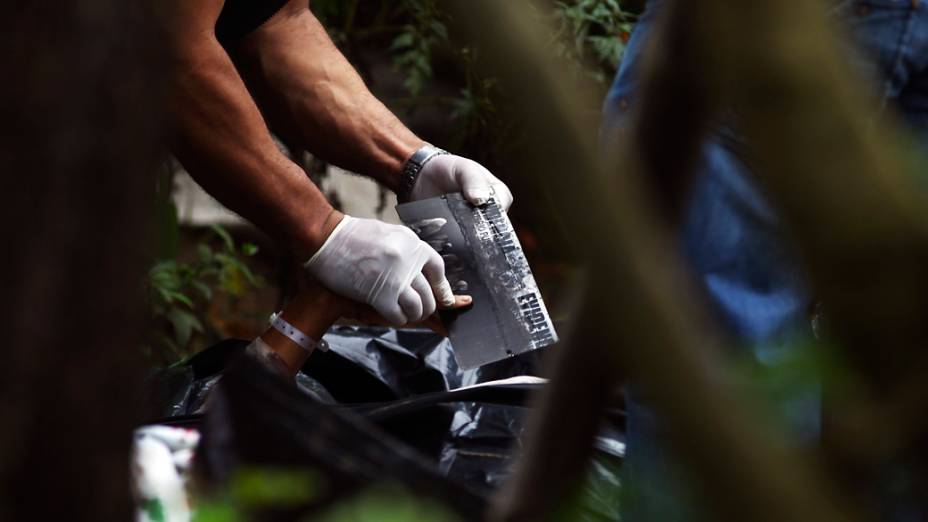 Equipe de perícia recolhe impressões digitais. Sete pessoas de uma mesma família foram assassinadas em Las Escobas, Guatemala