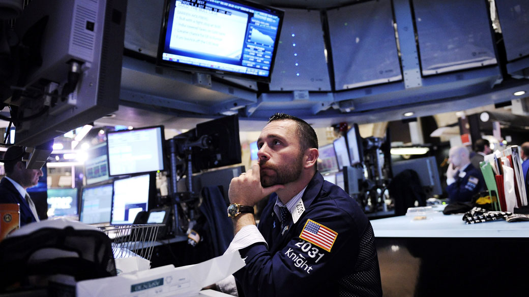 Corretores da Bolsa de Nova York observam a queda do índice Dow Jones