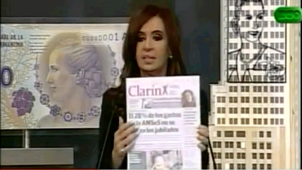 A presidente Cristina Kirchner exibe edição do jornal 'Clarín' durante pronunciamento. Autoridade aprovação divisão do grupo
