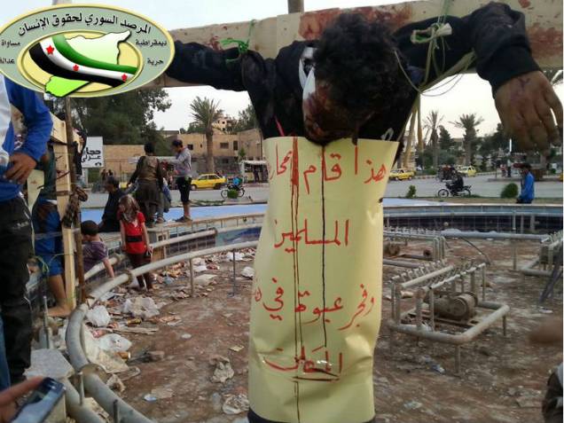 Pesssoas observam um homem morto e crucificado em Raqqa, na Síria