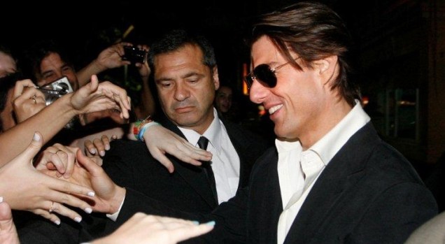 Tom Cruise cumprimenta fãs na saída do hotel em Copacabana: simpatia