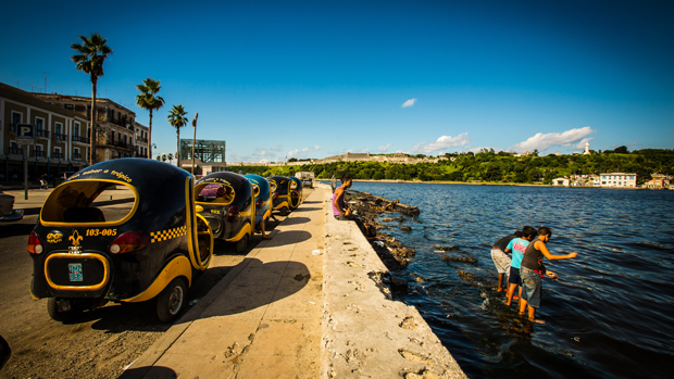 Cocotáxis de Havana. Os veículos são puxados por uma moto e os motoristas são funcionários estatais Cocotáxis de Havana. Os veículos são puxados por uma moto e os motoristas são funcionários estatais