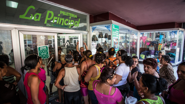 Mulheres aguardam abertura de loja estatal em promoção, em Camaguey