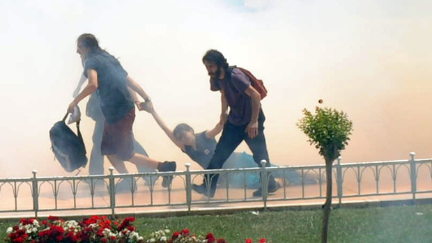 Mulher é puxada durante protesto contra a destruição do parque Taksim Gezi, em Istambul, na Turquia