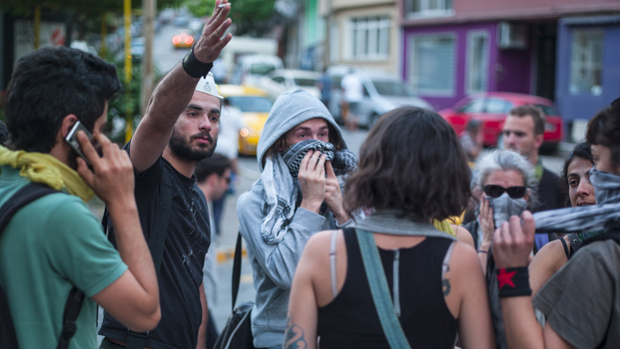 Pessoas cobrem o rosto para se proteger de gás lacrimogêneo usado pela polícia para dispersar manifestantes em Istambul