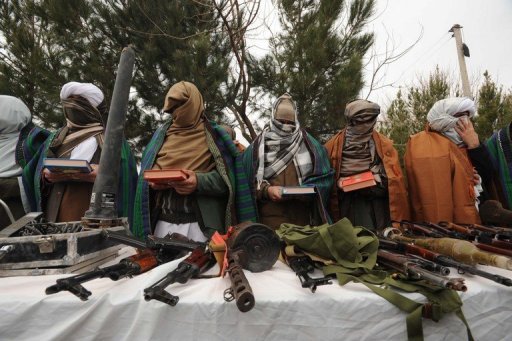 Combatentes talibãs posam com armas em Herat, Afeganistão, em 18 de fevereiro de 2012