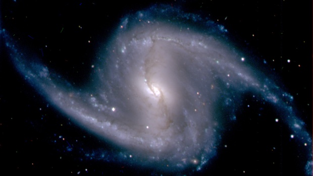 Imagem da galáxia espiral barrada NGC 1365, localizada no aglomerado de galáxias Fornax, a 60 milhões de anos-luz da Terra
