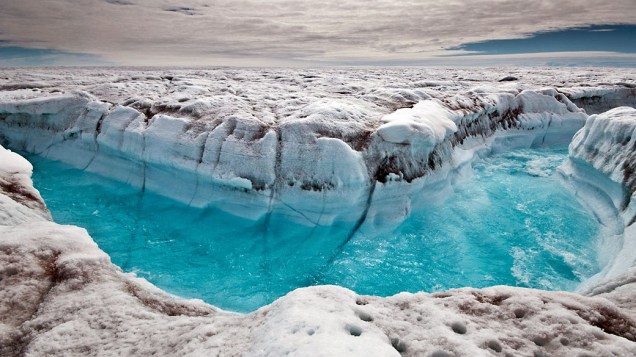 A água derretida corre na superfície da calota polar da Groenlândia, formando canais na superfície