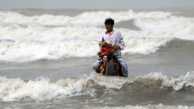 Homem paquistanês monta seu cavalo na praia de Clifton, em Karachi, no Dia Mundial do Meio Ambiente