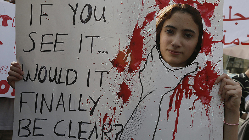 Ativista segura cartaz em passeata contra a violência doméstica contra a mulher, durante o Dia Internacional da Mulher em Beirute, no Líbano