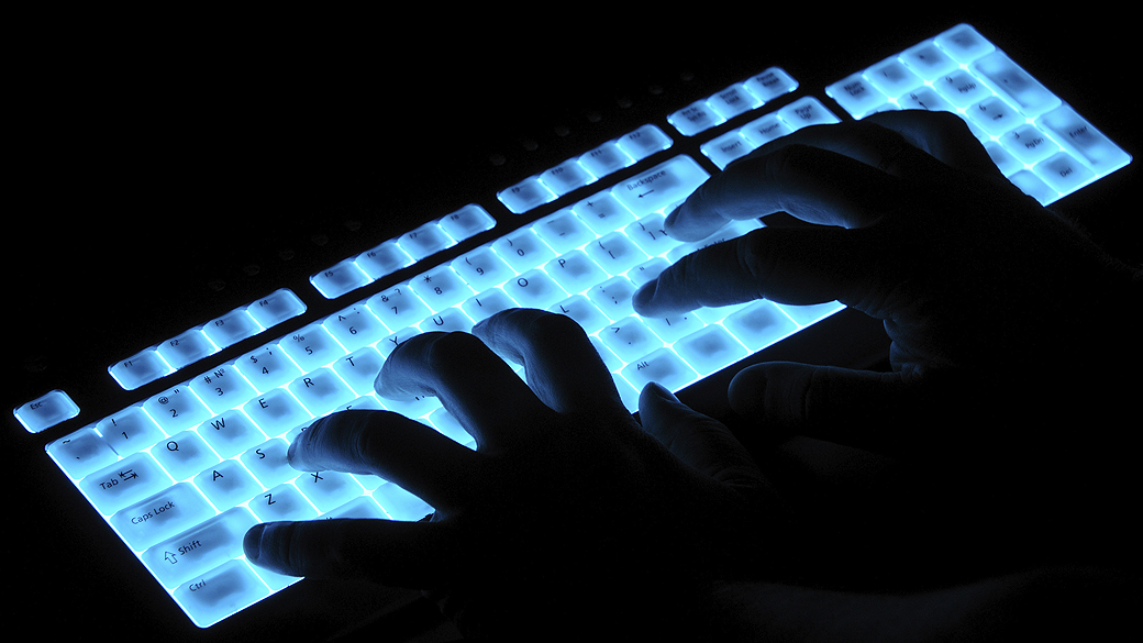 Hacker em um teclado luminoso