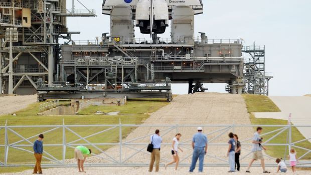 Visitantes passeiam perto da base de lançamento do ônibus espacial Discovery, no Centro Espacial Kennedy, na Flórida