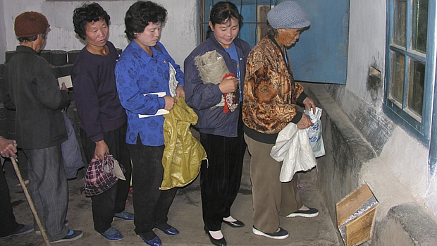 Norte-coreanas aguardam distribuição de comida em Pyongyang