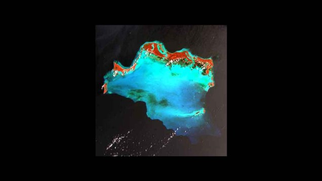 <p>Ilhas Caicos, Caribe, abril de 2003. A ilha aparece em vermelho e verde no limite norte de um banco de coral (retratado em turquesa). Caicos é um território ultramarino britânico e um famoso destino turístico</p>