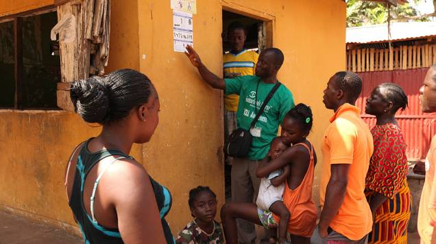 Na Libéria, agente de saúde da informações sobre a prevenção do vírus Ebola