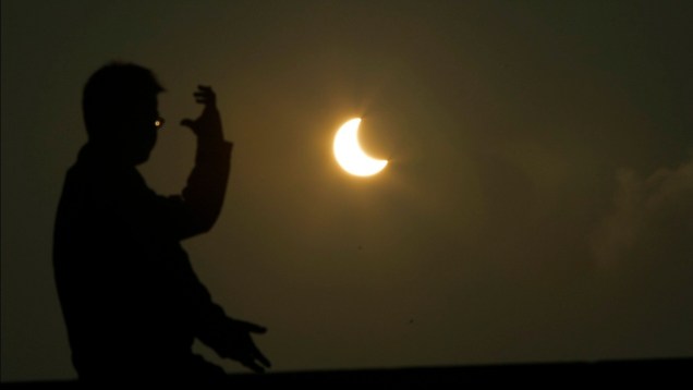 <p>Um homem pratica taichi durante o eclipse solar em Xangai, no dia 21 de maio</p>