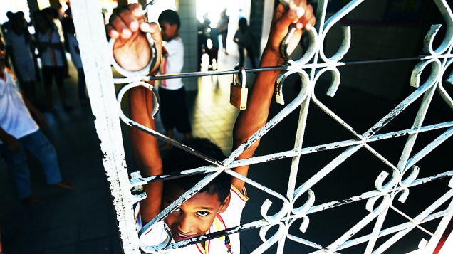 Aluno brinca em uma das poucas grades da escola Araújo Chaves, que tem muros baixos e espaços abertos à comunidade. "Vantagens de estar em uma comunidade pequena", diz a diretora Luidmila.
