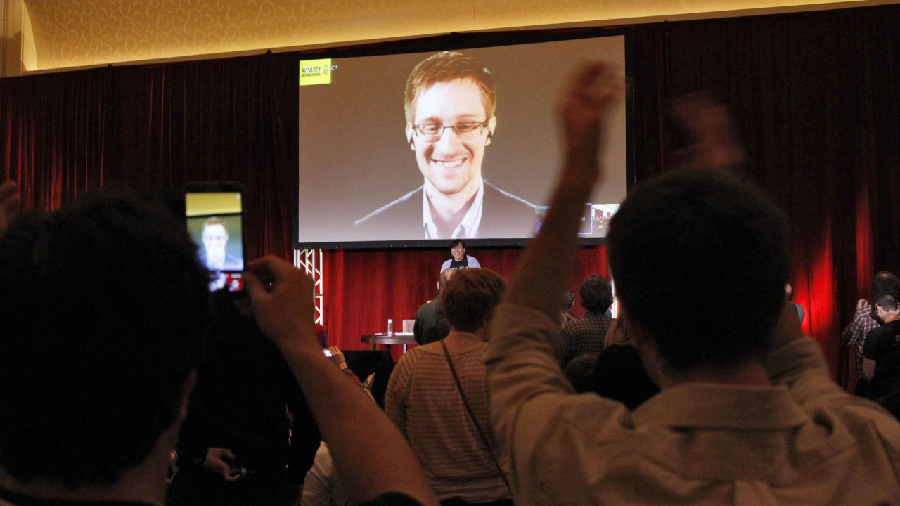 Edward Snowden é aplaudido por membros da Anistia Internacional durante uma videoconferência