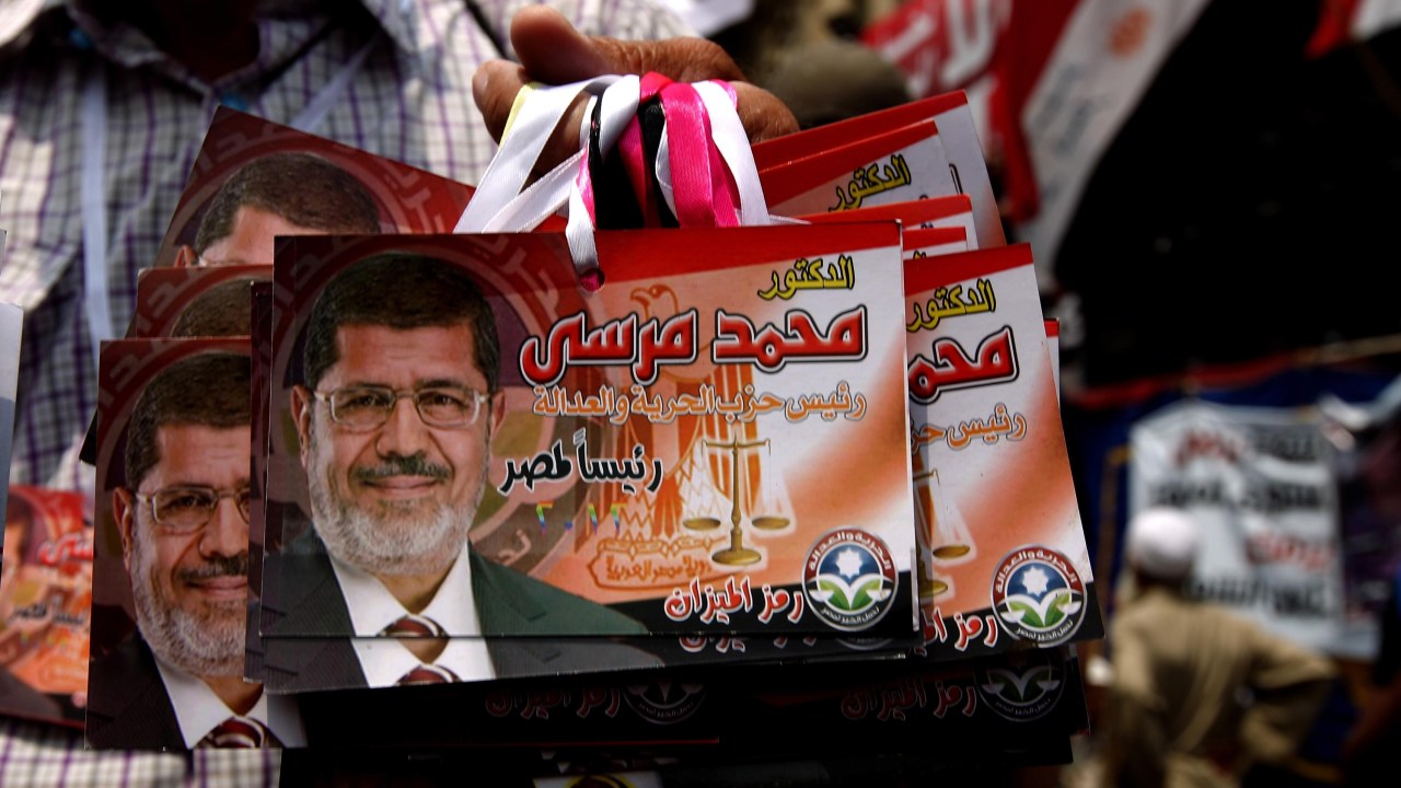 Vendedor exibe imagens de Mohamed Mursi, no Egito