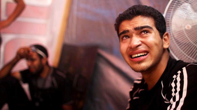 Jovem chora em um hospital de campanha após operação da polícia contra grupos de apoiadores do presidente deposto do Egito, Mohamed Mursi que deixou dezenas de mortos e feridos, perto da mesquita Rabea al Aduiya, no Cairo, nesta quarta-feira (14/08/2013)
