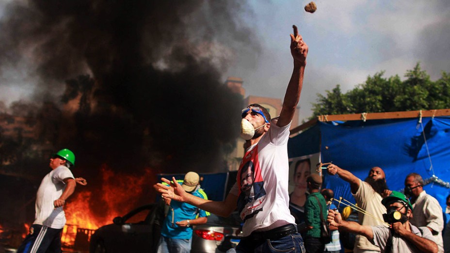 Manifestantes apoiadores do presidente deposto do Egito, Mohamed Mursi, entram em confronto com a polícia durante protesto na praça Al-Nahda, no Cairo, nesta quarta-feira (14/08/2013)