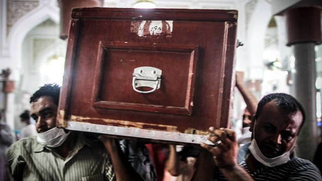 Homens carregam caixão de manifestante morto durante os confrontos com a polícia na quarta-feira (14) durante um funeral no Cairo - (15/08/2013)