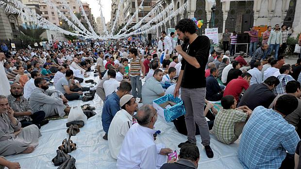 Egípcios sentam aguardando horário da oração do Eid al-Fitr