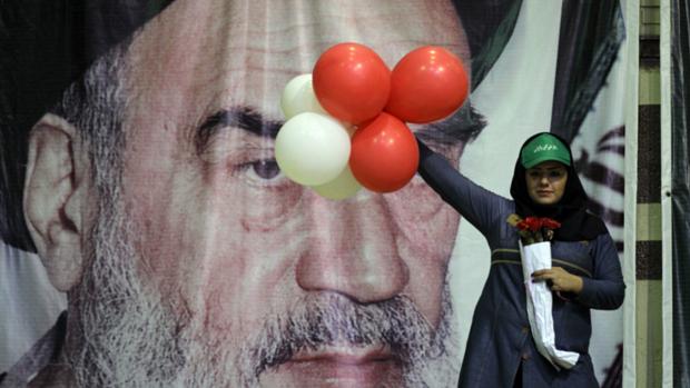 Apoiadora do candidato Ali Akbar Velayati diante de pôster com imagem do líder supremo do Irã, o aiatolá Ali Khamenei, em Teerã