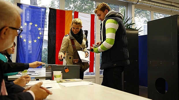 Eleitora deposita cédula em urna em Berlim; expectativa é de vitória de Merkel