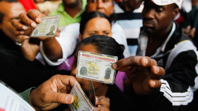 Cidadãos venezuelanos exibem documentos de identidade durante eleições presidenciais em Caracas