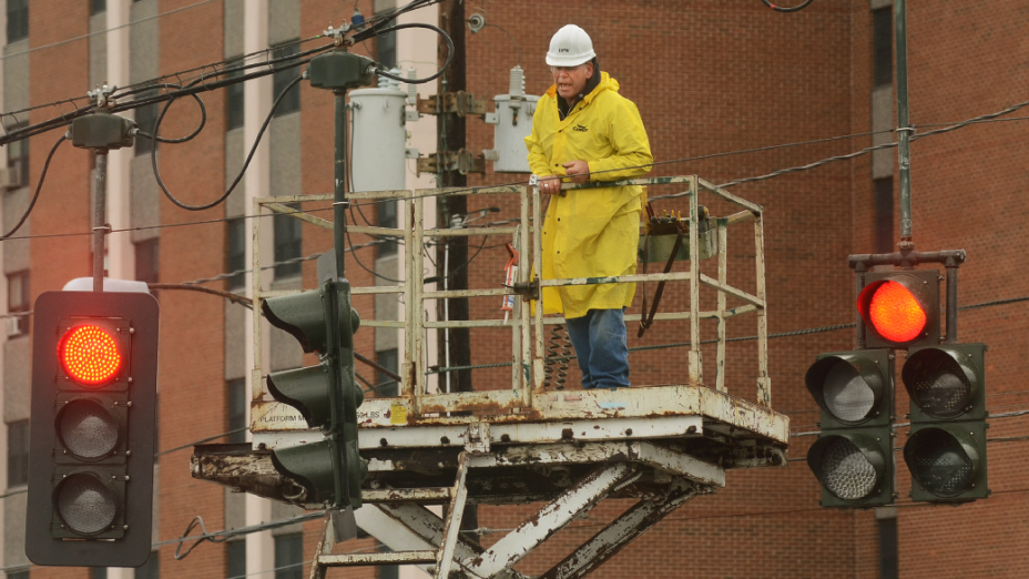Eletricista conserta semáforo destruído pela tempestade Sandy na cidade de Elmira, em Nova York