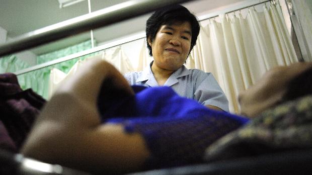 Enfermeira tranquiliza paciente durante exame de câncer cervical em Poyai, Tailândia