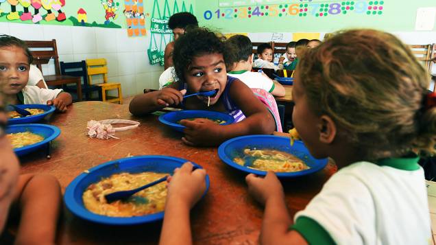 Alunos da educação infantil comem merenda na escola Cícero Barbosa Maciel, em Pedra Branca, Ceará. Alunos menores comem em sala antes de sair para o recreio. Estratégia foi pensada pela diretoria da escola para evitar desperdício de comida, já que as crianças acabavam comendo com pressa para brincar.