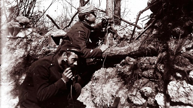 Oficiais da artilharia francesa recebem instruções por telefone para ajustar um canhão