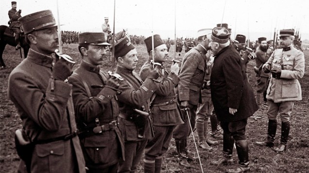 O general francês Joseph Joffre (à dir, de uniforme escuro) cumprimenta militares que lutaram na Batalha de Verdun, em março de 1916