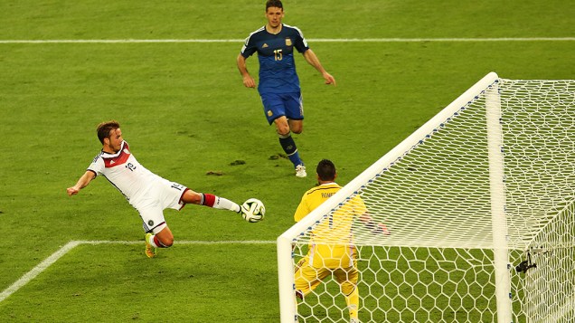 O alemão Götze chuta e marca gol na Argentina no segundo tempo da prorrogação na final da Copa no Maracanã, no Rio