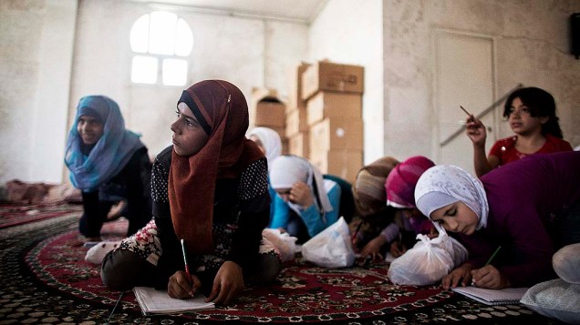 Filhos de refugiado da Síria assistem à aula em uma escola improvisada na cidade de Azaz, na fronteira com a Turquia