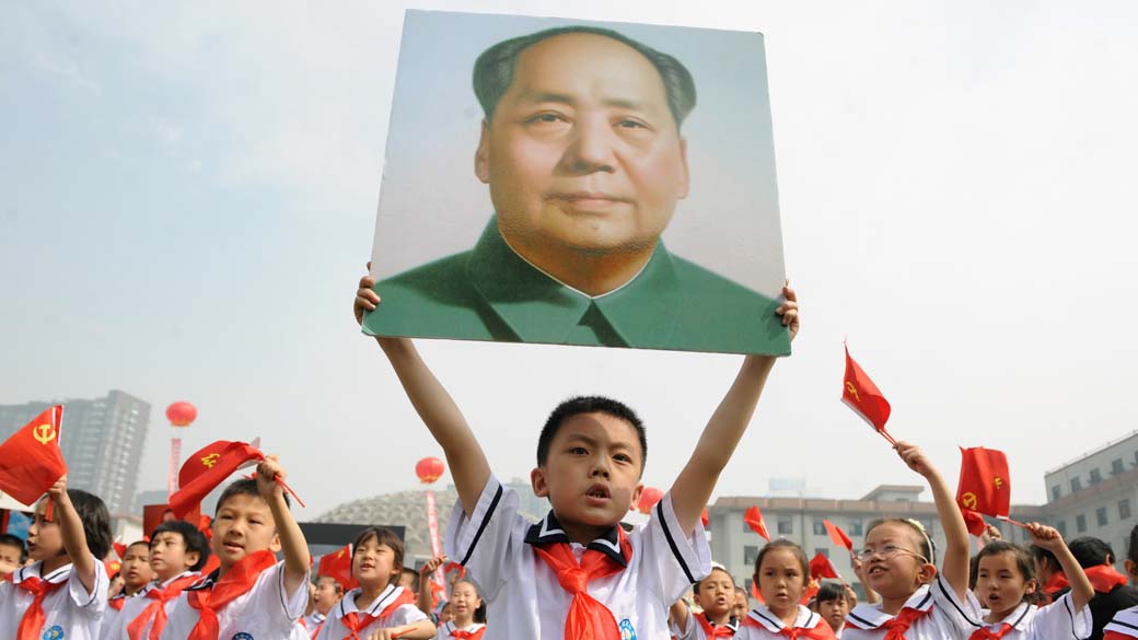 Na cidade de Taiyuan, estudante chinês carrega retrato do líder Mao Zedong, durante a celebração do 90º aniversário da fundação do Partido Comunista