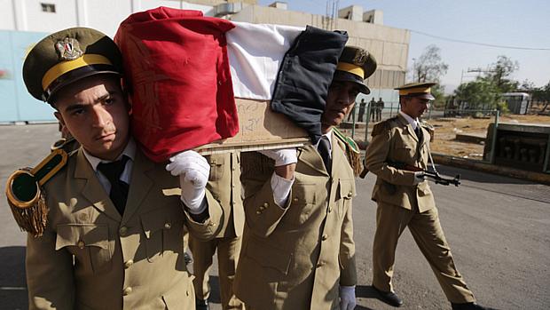 Soldados do Exército sírio carregam caixão de militar em funeral