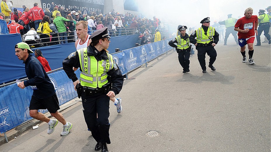Policiais e pessoas correm após as duas explosões na maratona de Boston