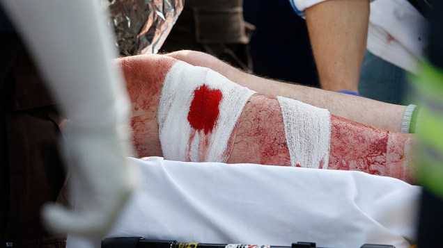 Homem ferido é socorrido em uma ambulância estacionada em uma tenda médica localizada próximo ao local de chegada da Maratona de Boston