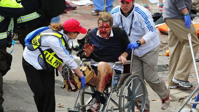 Homem ferido na explosão perto da linha de chegada da Maratona de Boston é retirado em uma cadeira de rodas