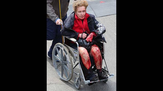 Mulher ferida recebe atendimento de equipes de resgate, após duas explosões na maratona de Boston