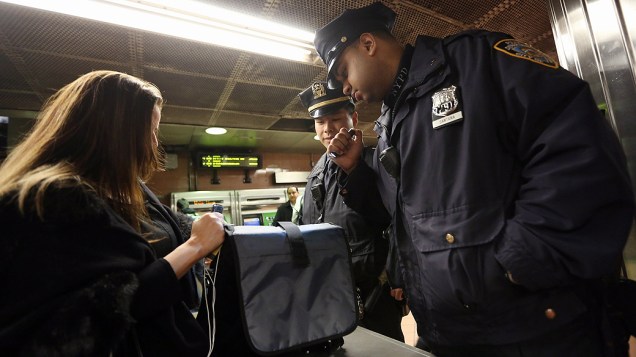 Policiais inspecionam mala de mulher no Grand Central Terminal, em Manhattan, Nova York